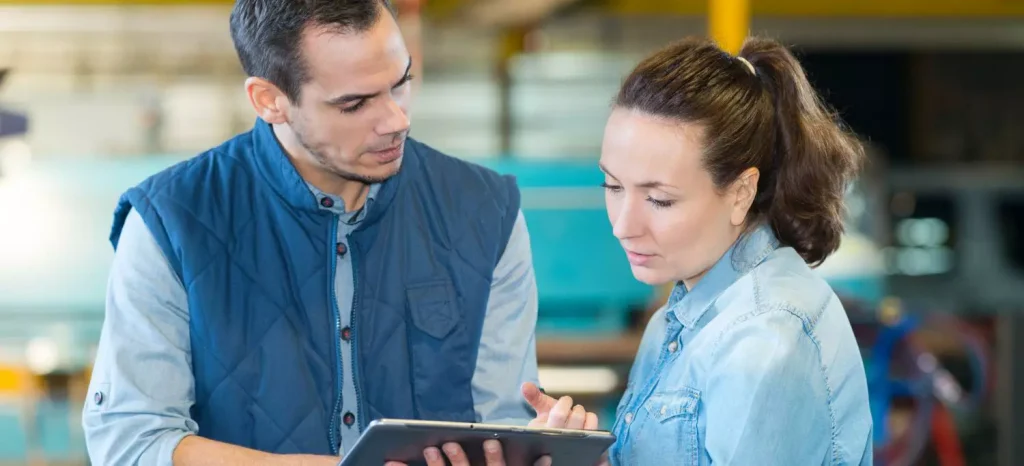 Warehouse Specialist Auditing a TRIF on a clipboard as another employee looks on
