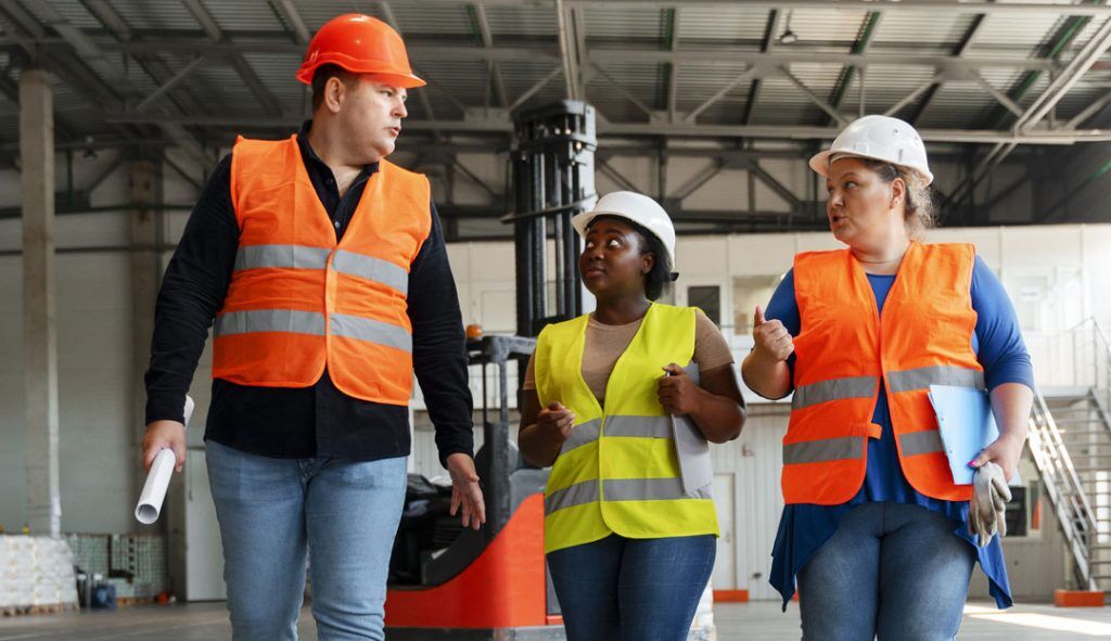 Three workers discussing something while at their job